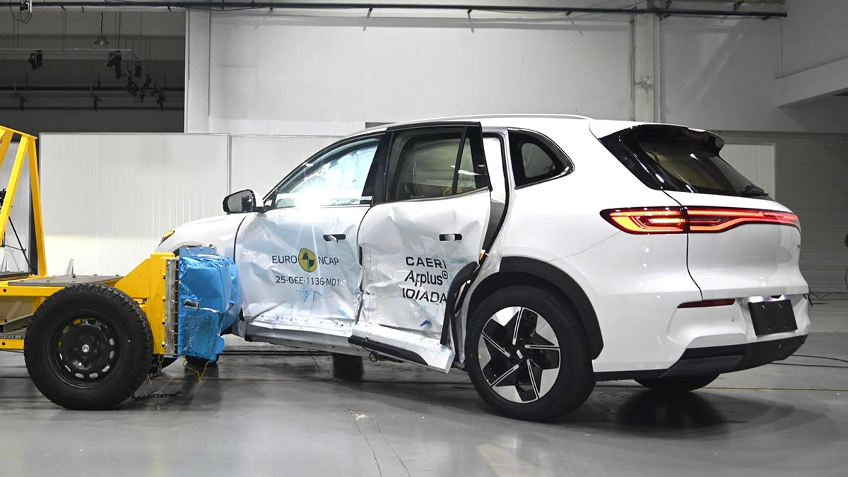 White Geely EX5 SUV with heavily dented side panels after collision with barrier in Euro NCAP side impact test. 
