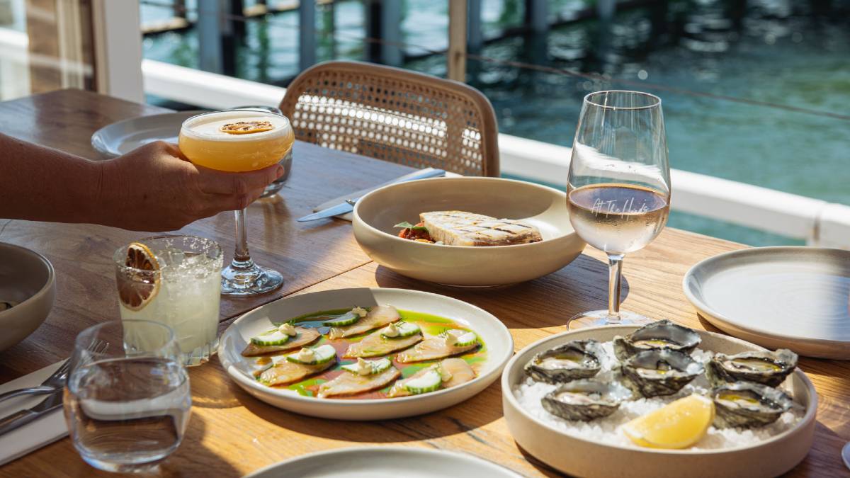 oceanside restaurant table with oysters and cocktails