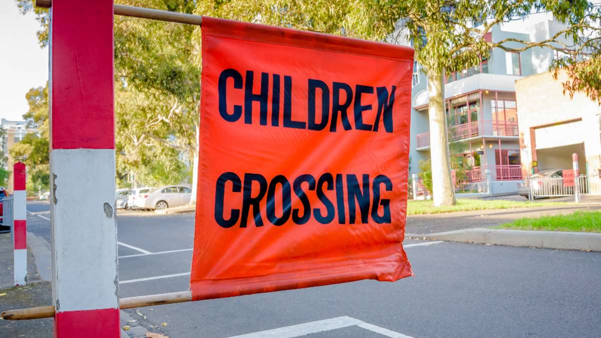 An orange children crossing sign