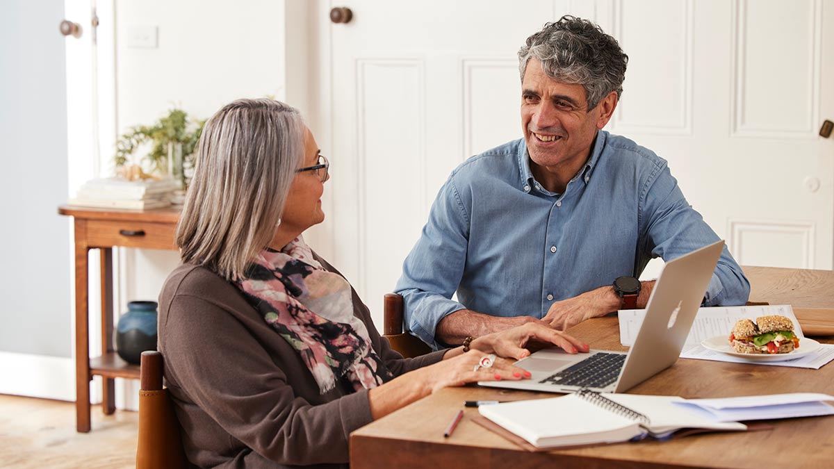 Man and woman at home seated at table discussing finance and insurance
