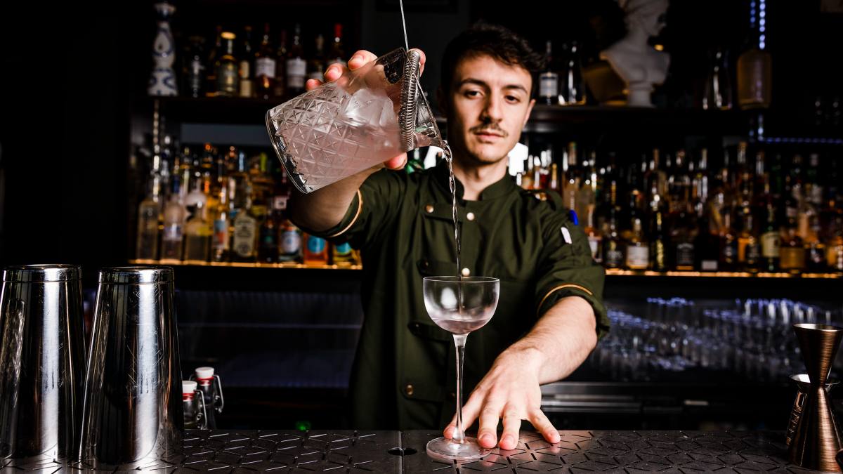 young bartender pouring a cocktail