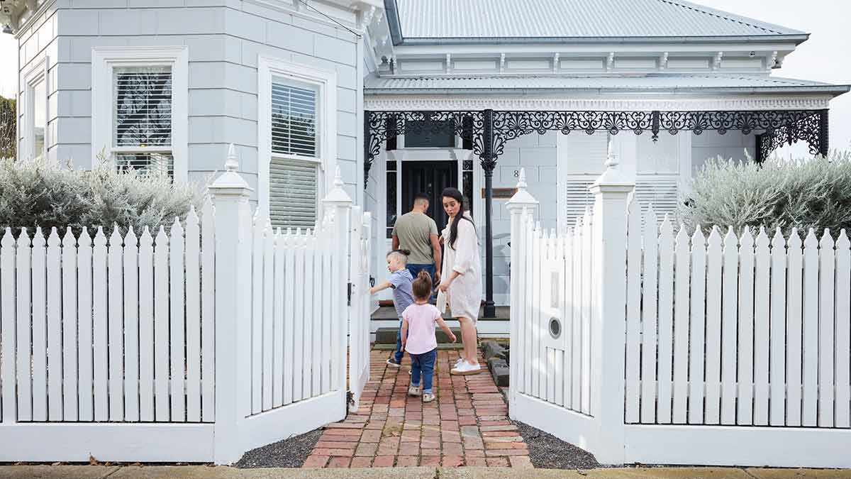 Couple with young children on front path of home