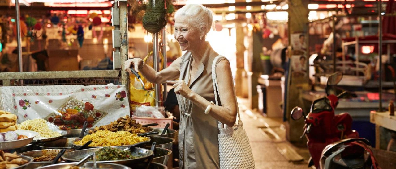senior woman at a street food market overseas