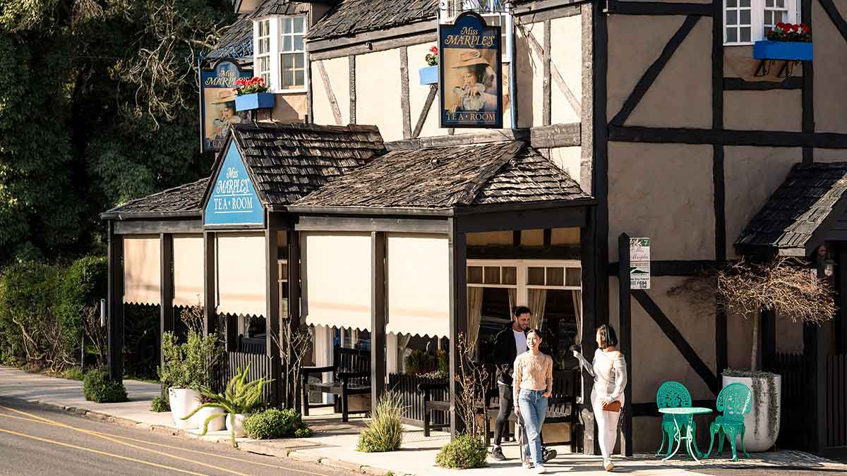Three people outside historic tearooms