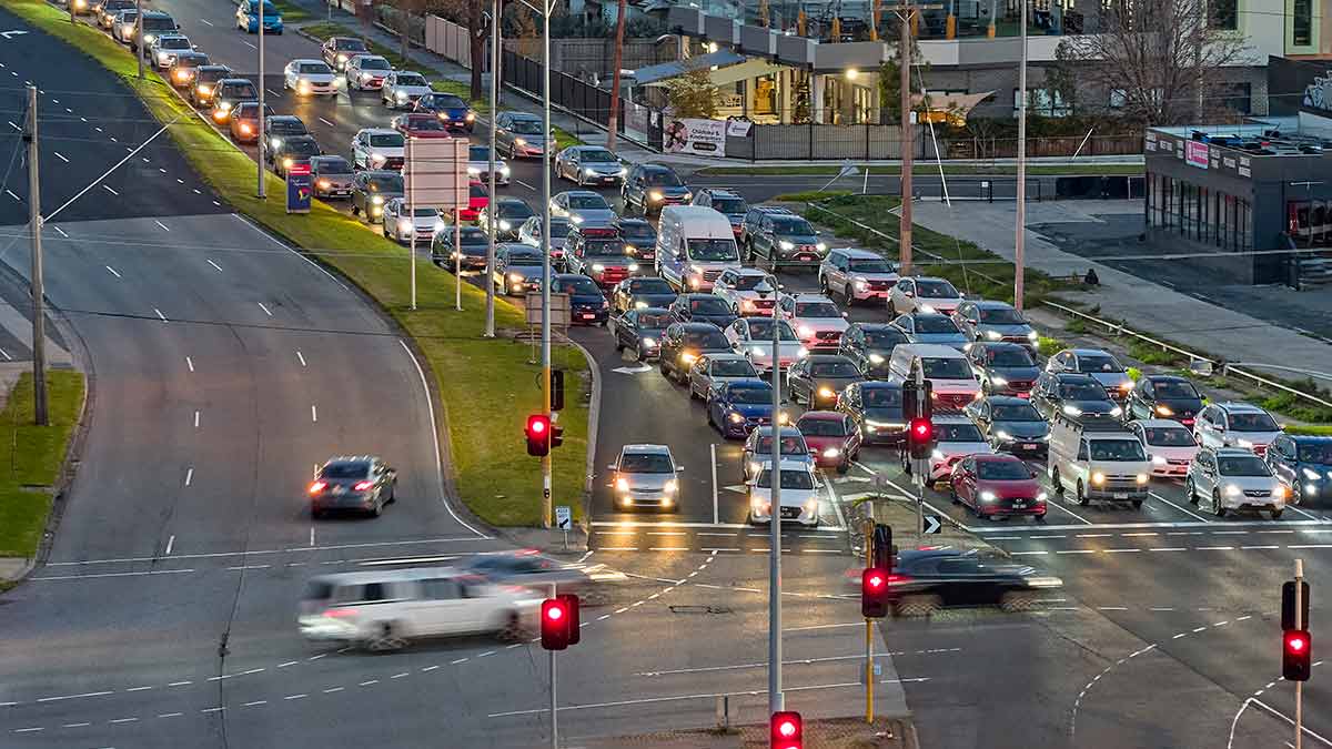 Long line of traffic stopped at red light at intersection