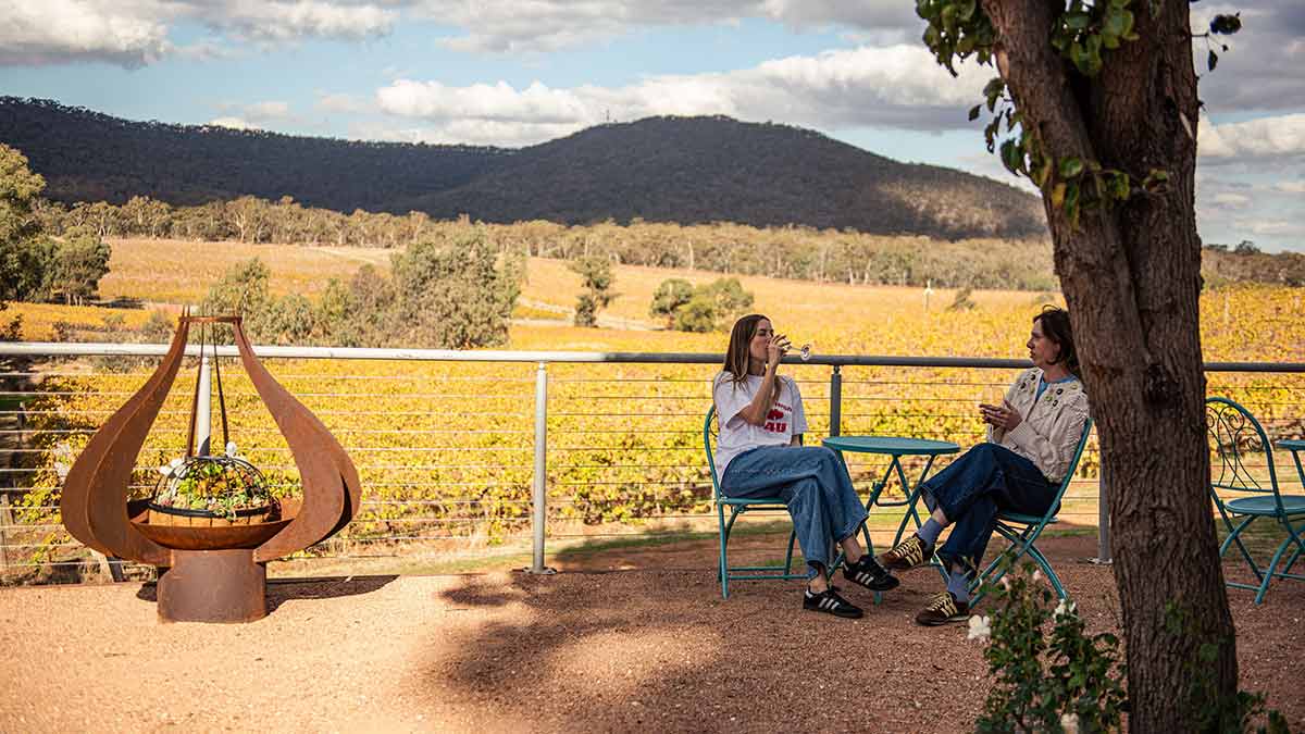 Two women relaxing and drinking wine at Sanguine Estate in Heathcote, central Victoria.