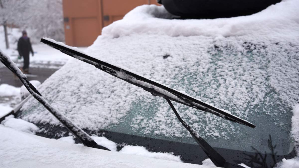Raised windscreen wipers on a snowy car