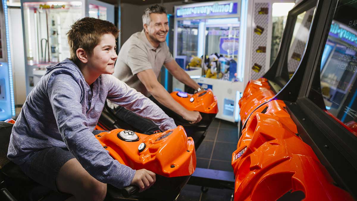 Father and son enjoying arcade simulator ride