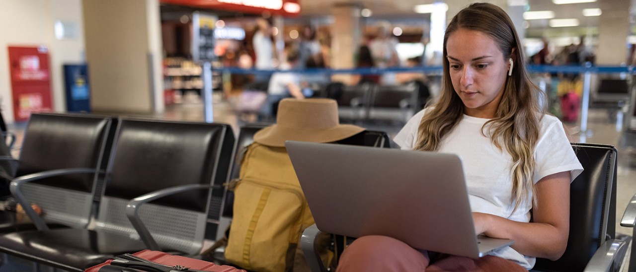 Female traveller on computer at airport.