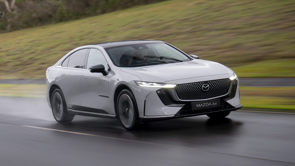Light grey LHD Euro-spec Mazda 6e sedan driving on wet road at Lang Lang proving ground in Victoria.