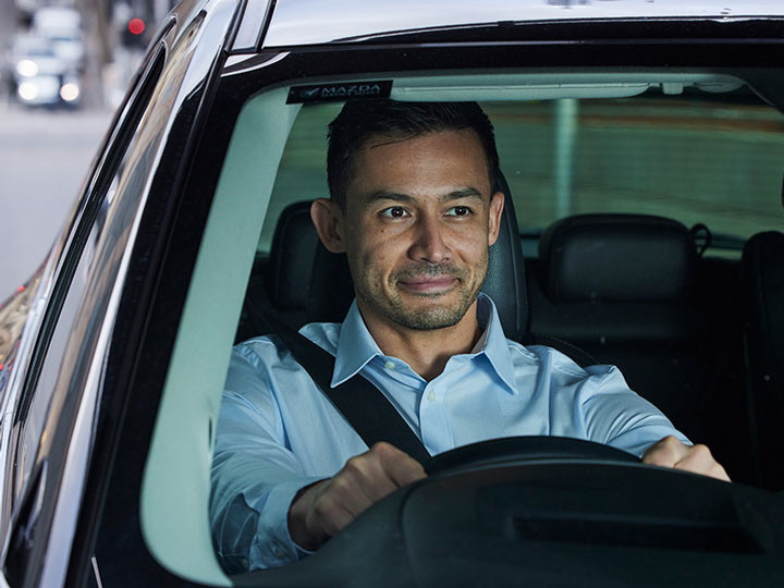 Man driving black vehicle.