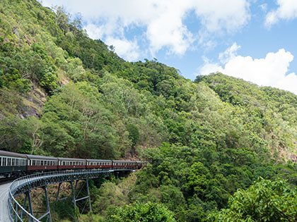 Train curving through green mountains.