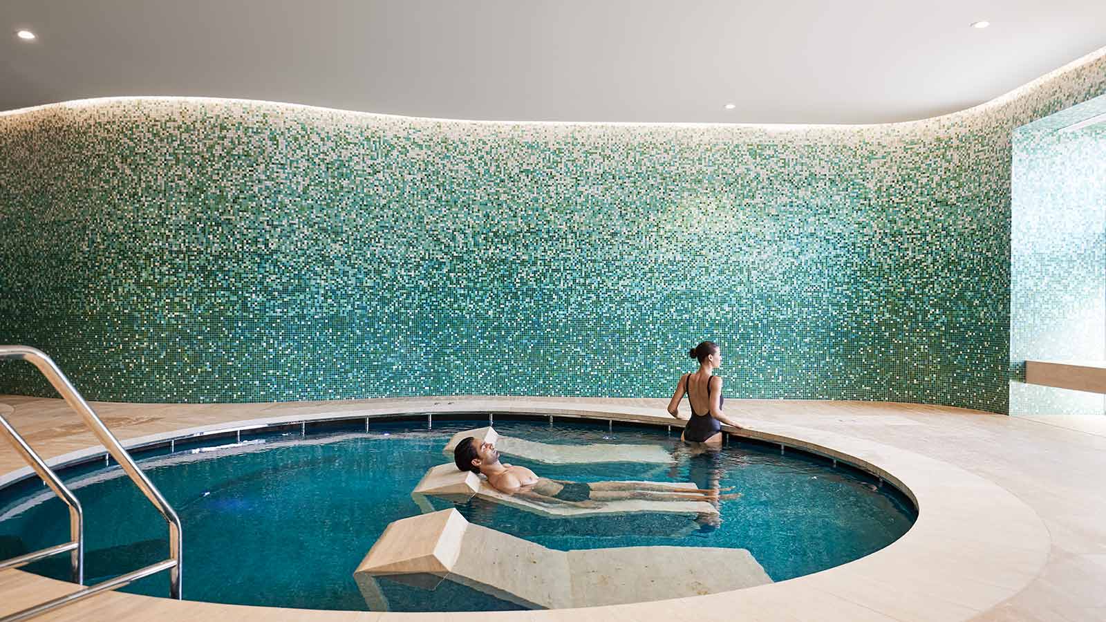 Two people in a pool with day beds at Cape Schanck One Spa.