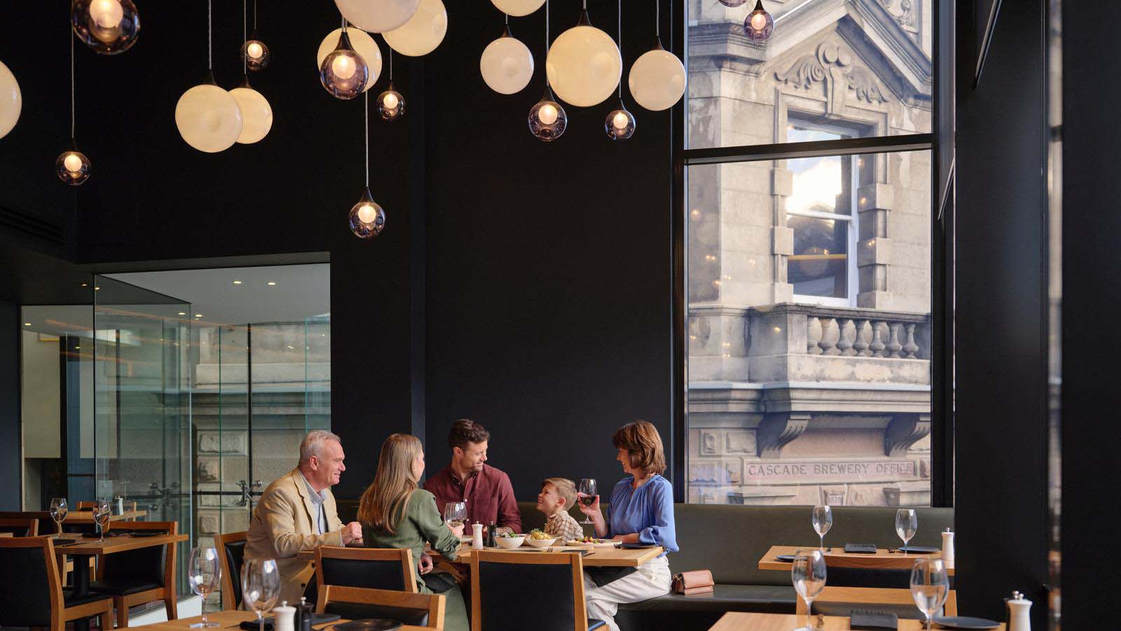 An extended family enjoying dinner at Hobart Hotel's Charcoal restaurant.