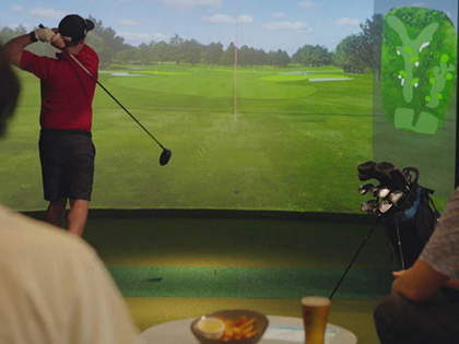 Person playing golf on simulator at Barooga Sports Club.