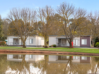 Accommodation cabins next to a lake at Cobram Resort.