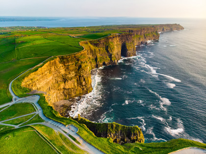 Beautiful green grassy cliffs on a clear day on the edge of the water. 