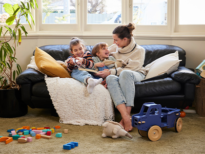 Family sitting on their couch and laughing together.