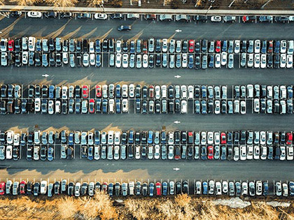 A large carpark that is full of parked cars.
