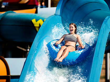 Girl going down a water slide on a tube at funfields