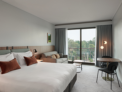Resort king room at RACV Goldfields Resort, featuring a king bed, couch and tables.