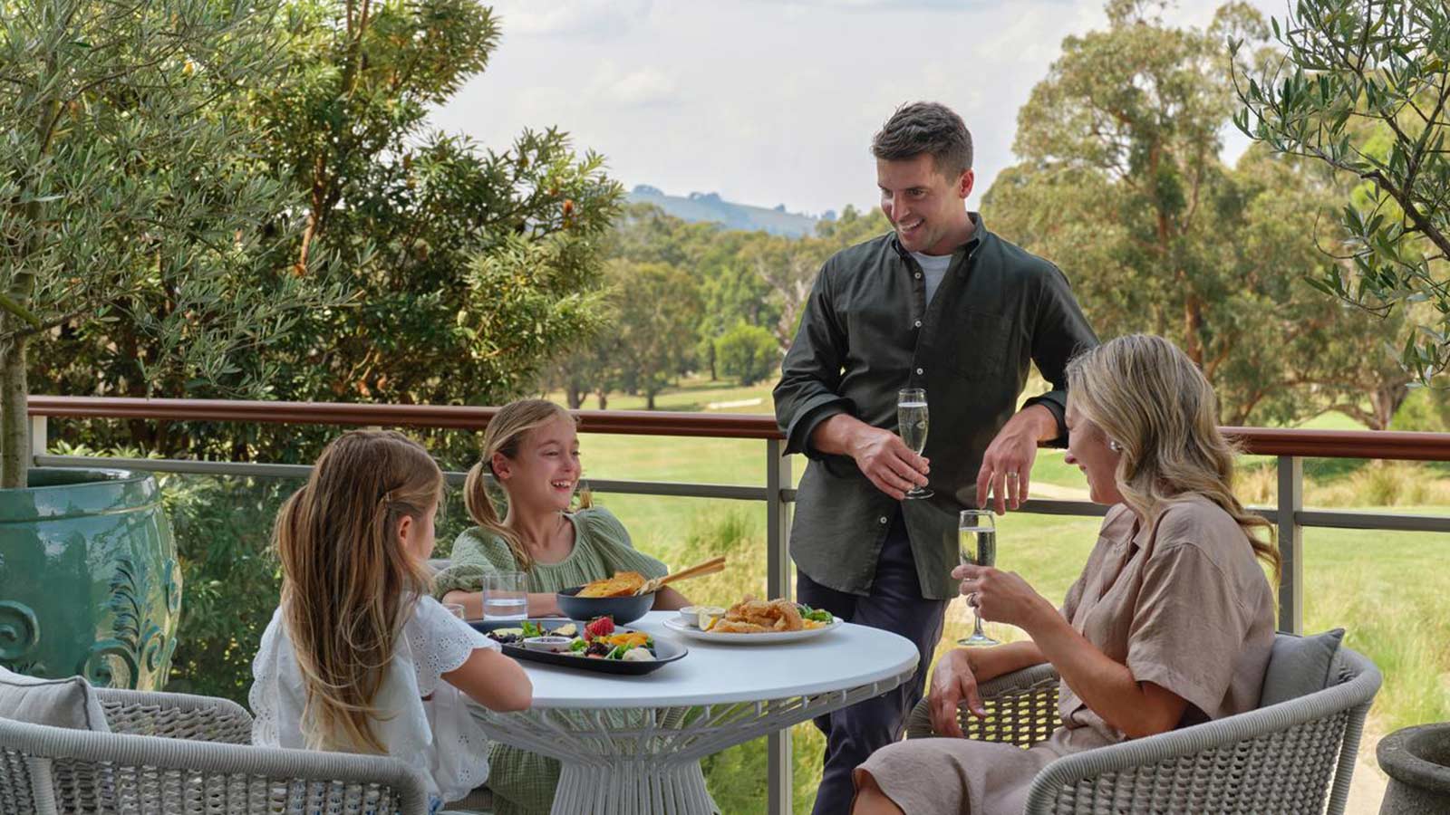 Family enjoy a meal on the terrace of Springs restaurant at RACV Goldfields resort.