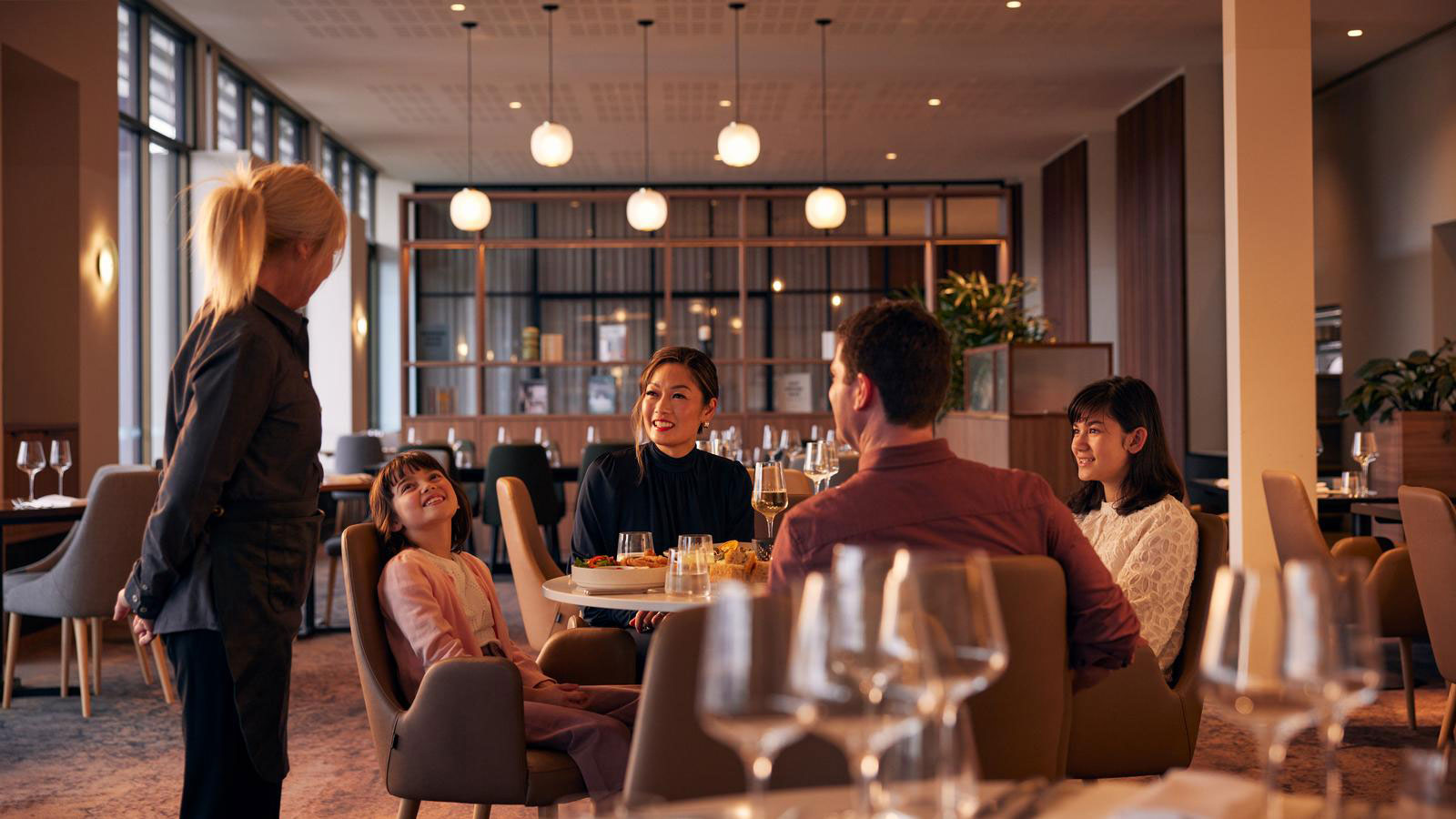 Waiter serving family dining at Banyalla restaurant at RACV Healesville Country Club and Resort.