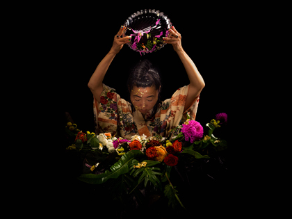 A woman photographed with a bright bunch of flowers. 