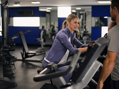 Two people smiling while using the gym facilities at RACV Hobart Hotel.
