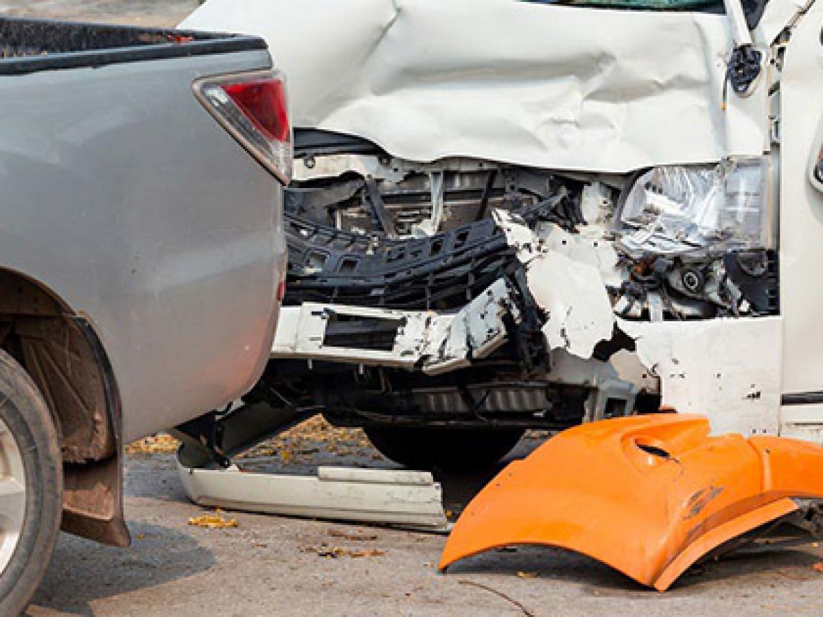 Close view of a car accident involving a ute and white van.