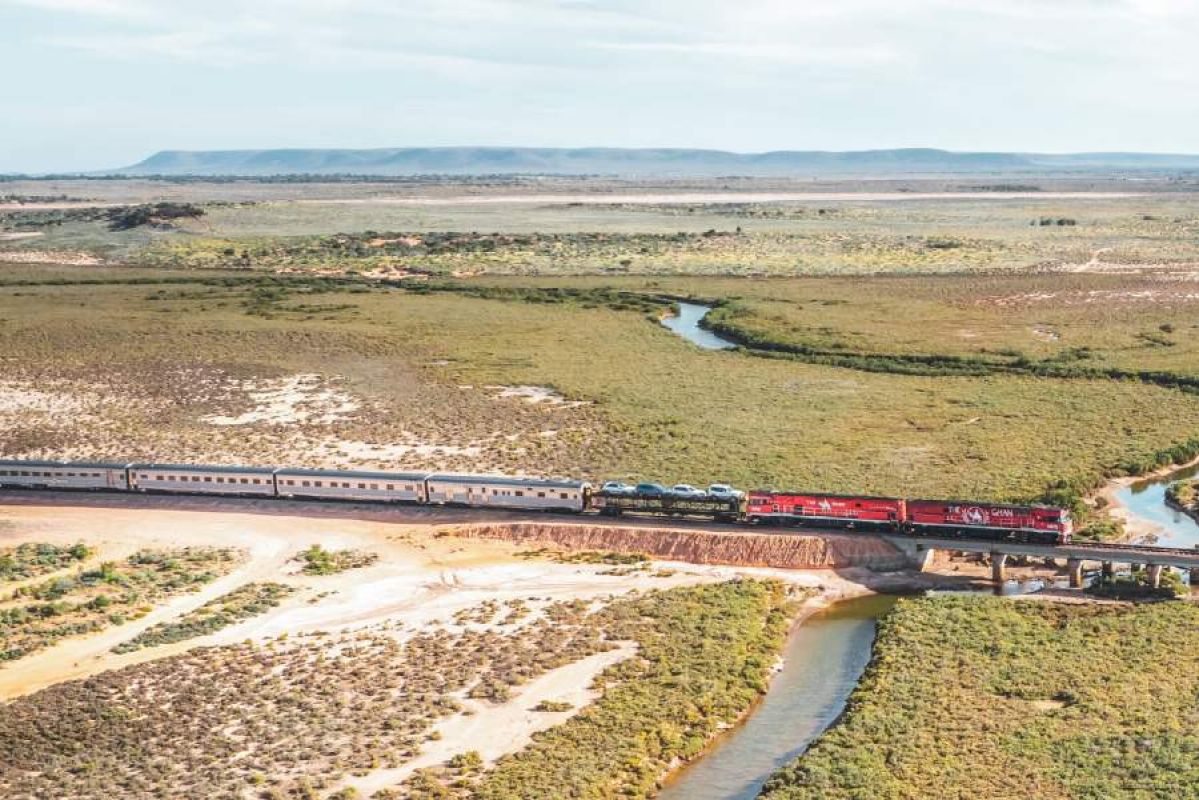 red train crossing river in Flinders Ranges area
