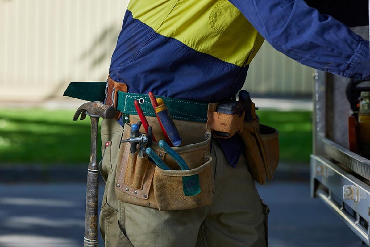tradesman with assortment of tools in a tool belt