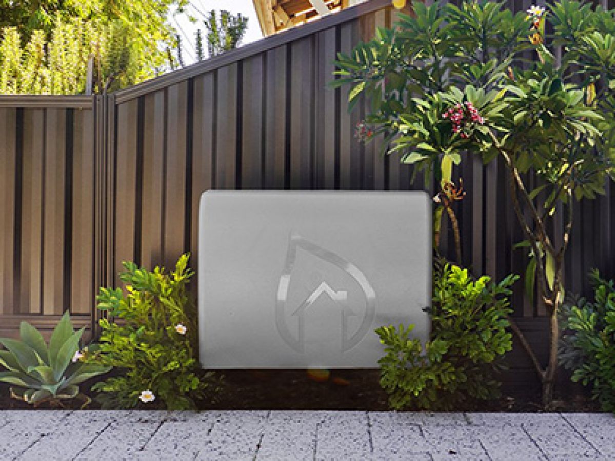 Home filtration system mounted on a fence in a garden bed.