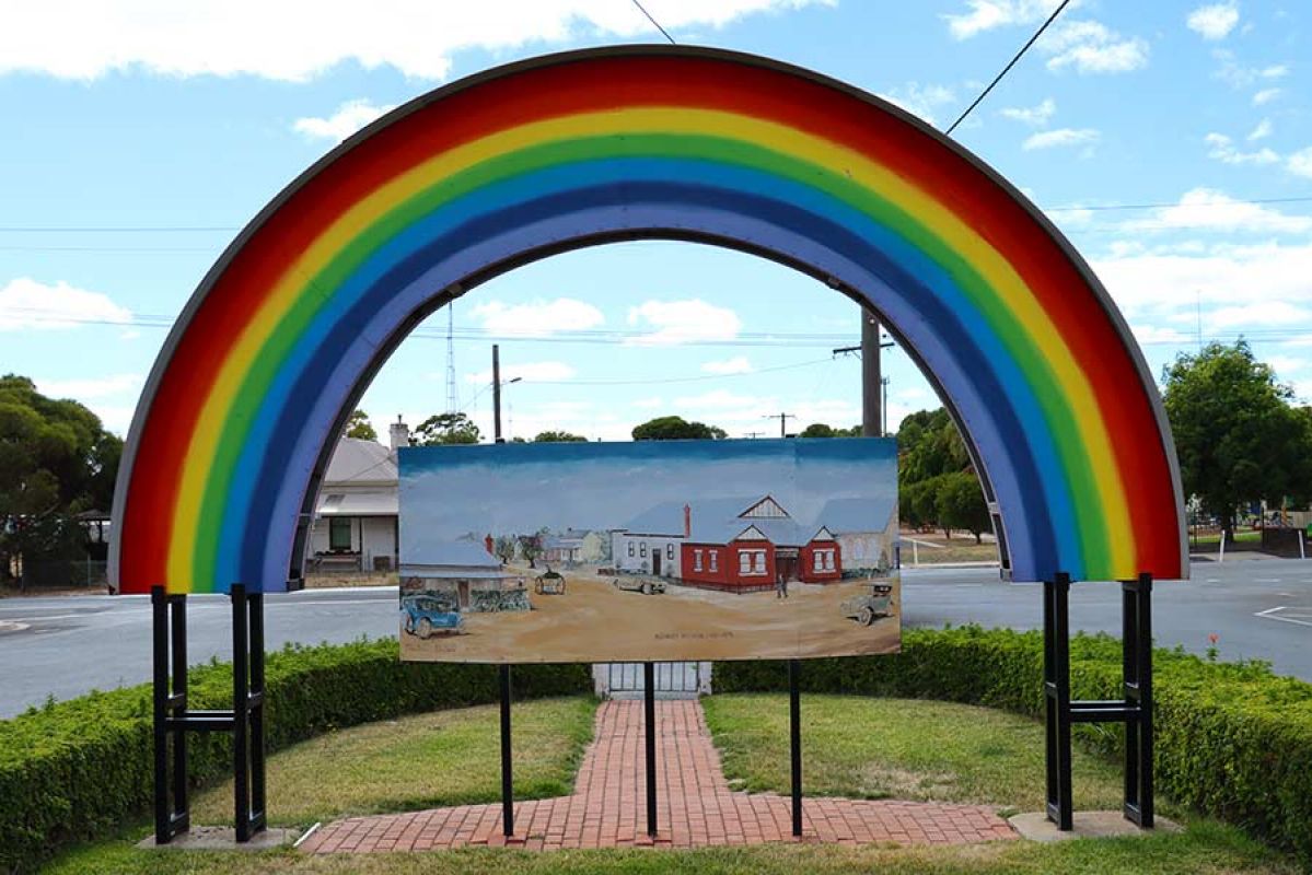 rainbow sign at entrance to small town