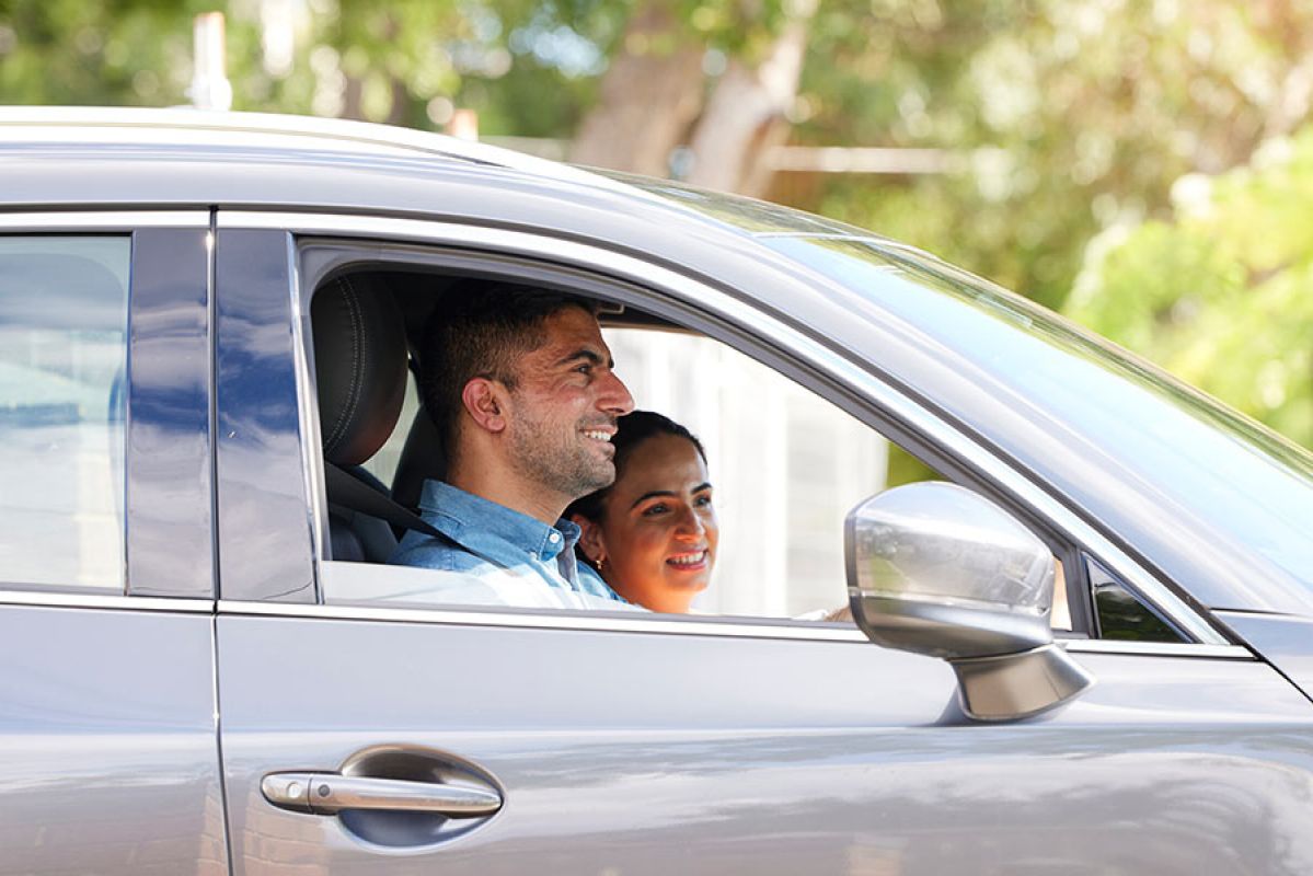 man and woman smiling at each other in car