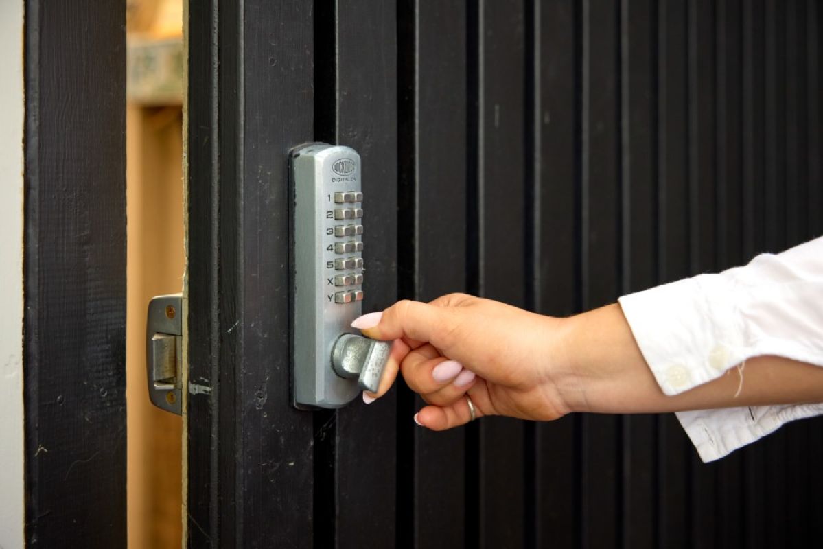 woman opening a door with a deadbolt keypad lock