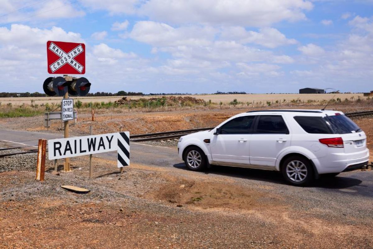 A white station wagon crossing a level crossing in regional Victoria