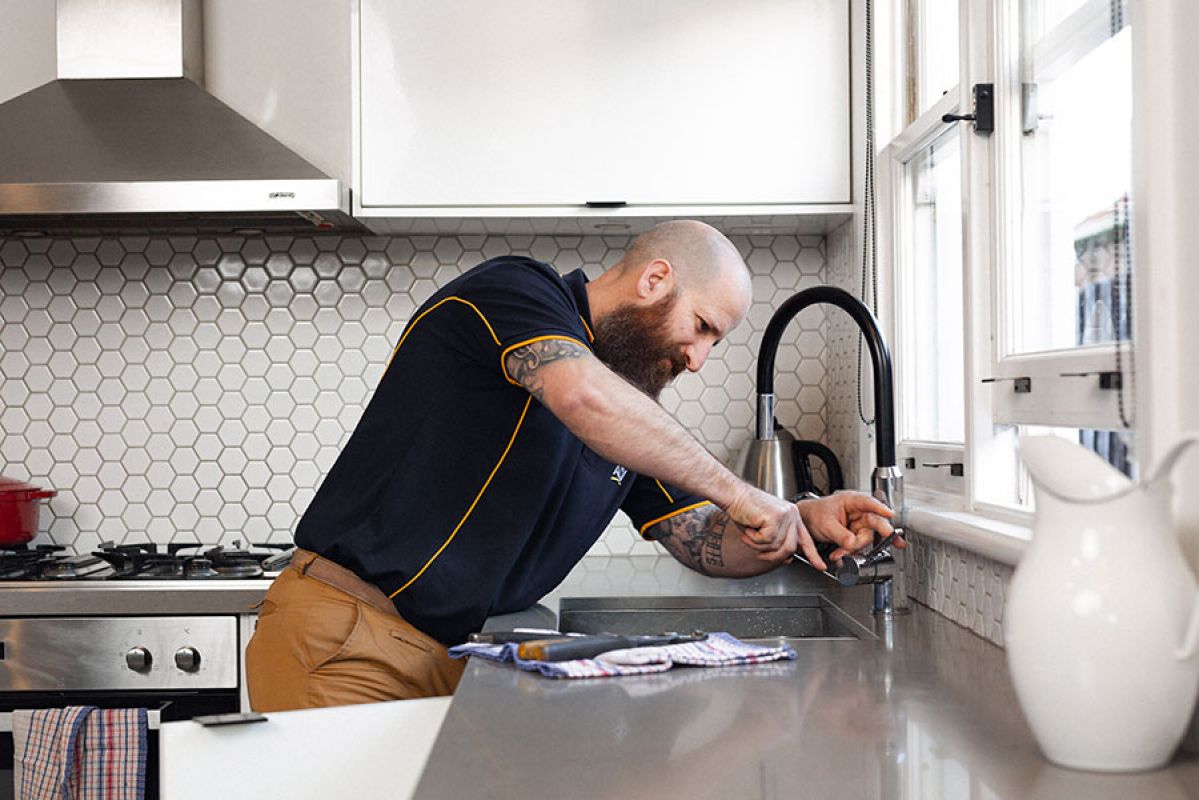 Man fixing leaking tap