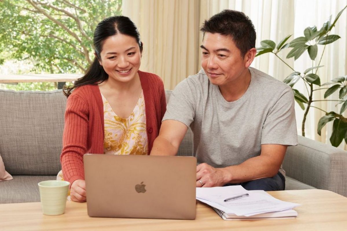 A couple happily planning in front of a laptop