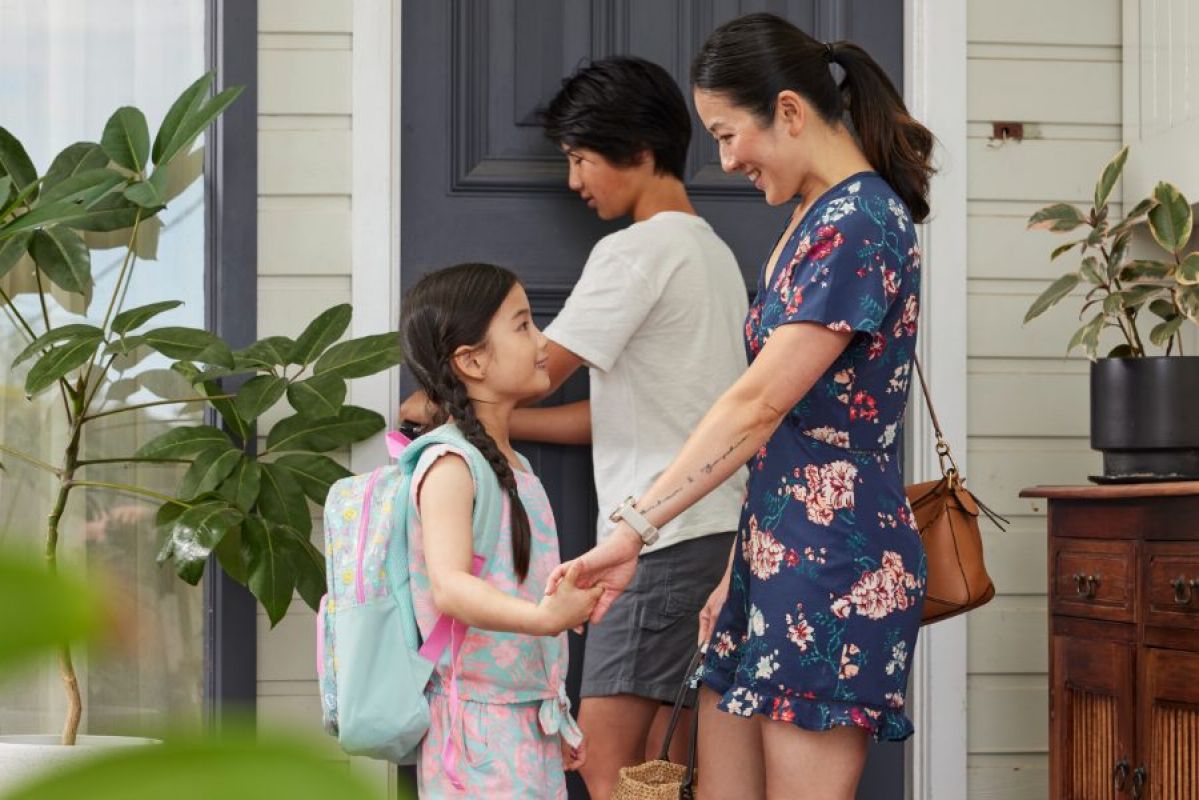 young family of three outside their home