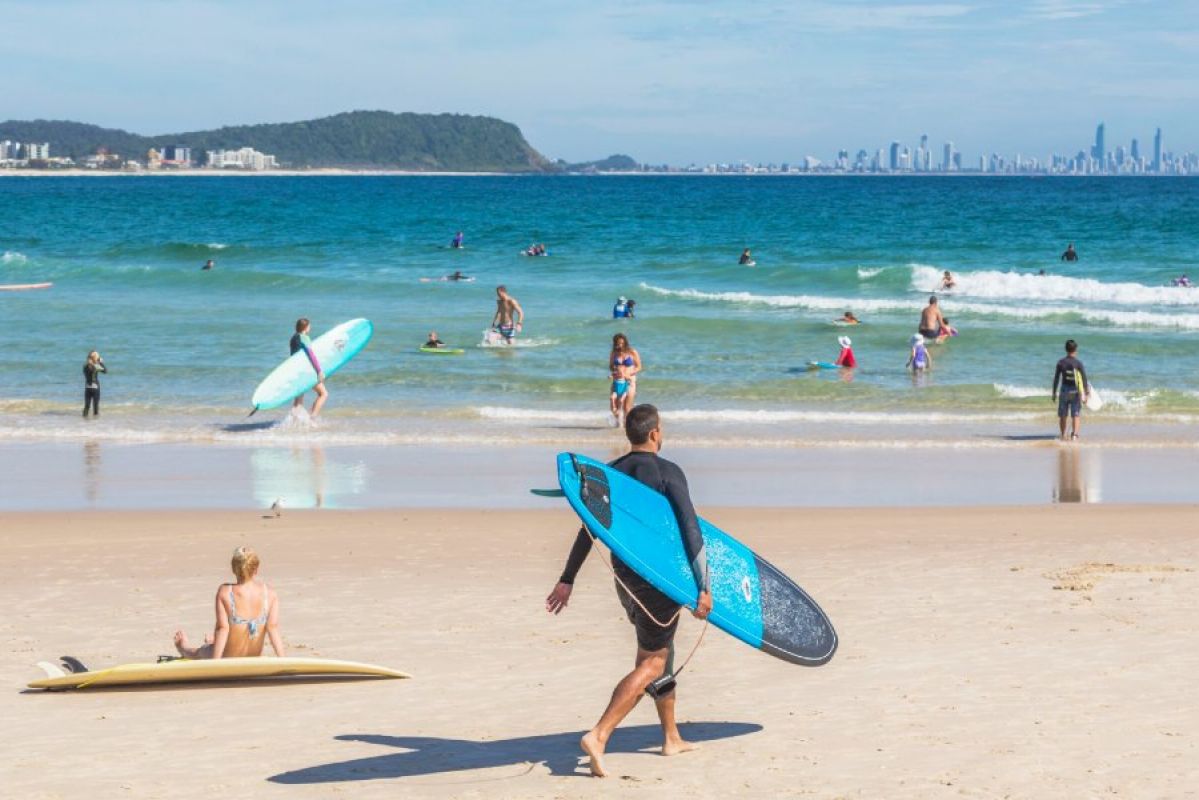people swimming and surfing at Gold Coast Beach