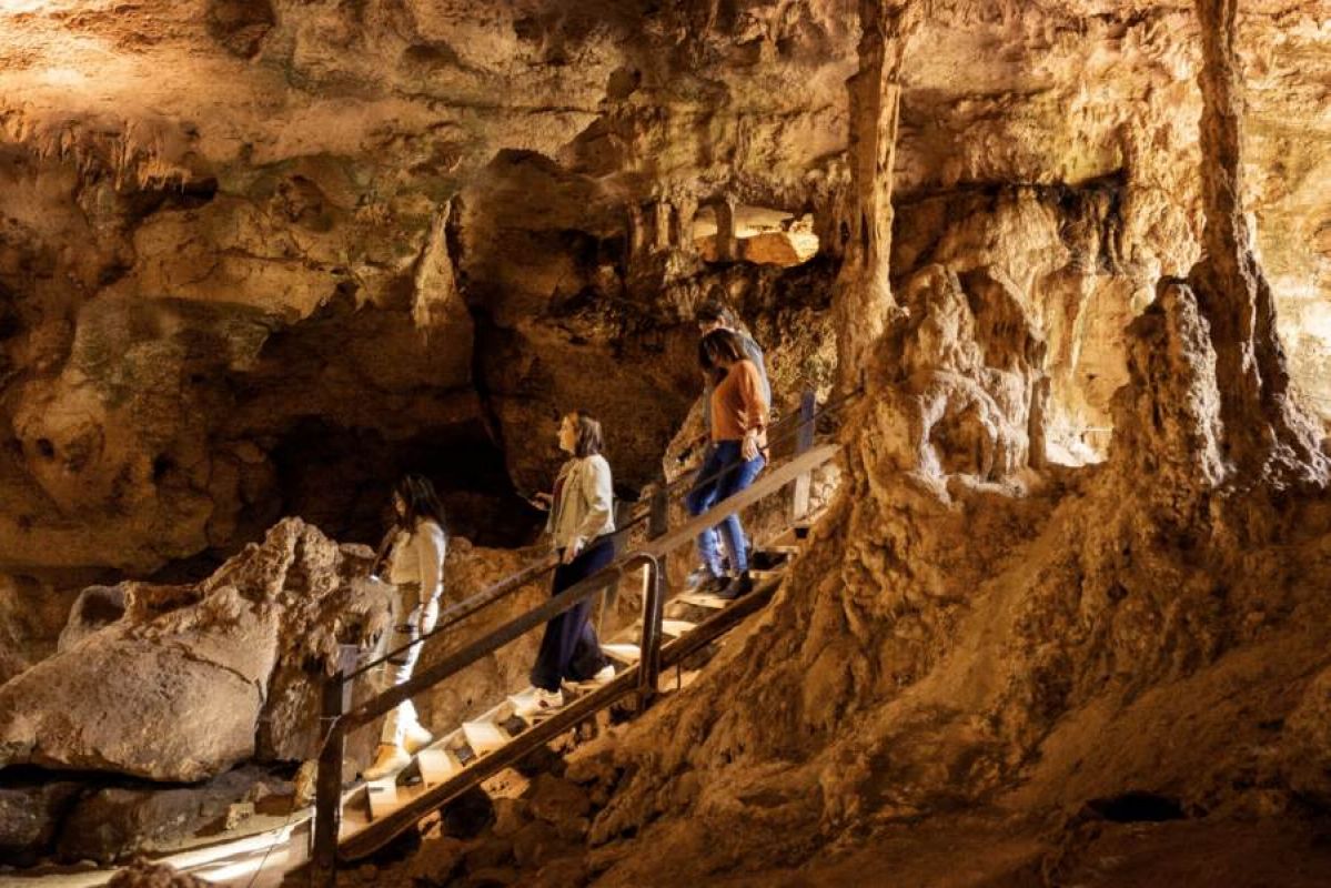 three women descending into well-lit caves
