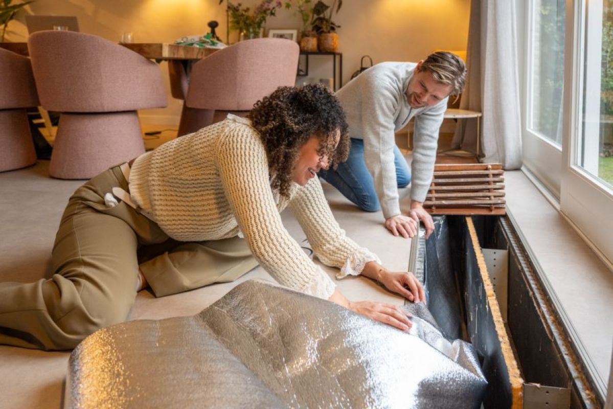 woman and man DIY installing insulation in their home