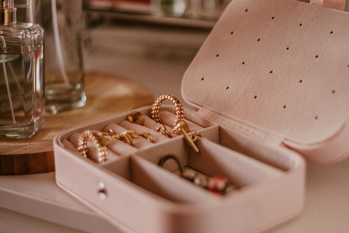 pink seude jewellery box filed with gold earrngs and rings