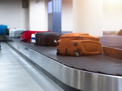 Airport lugaage carosel with several suicases.