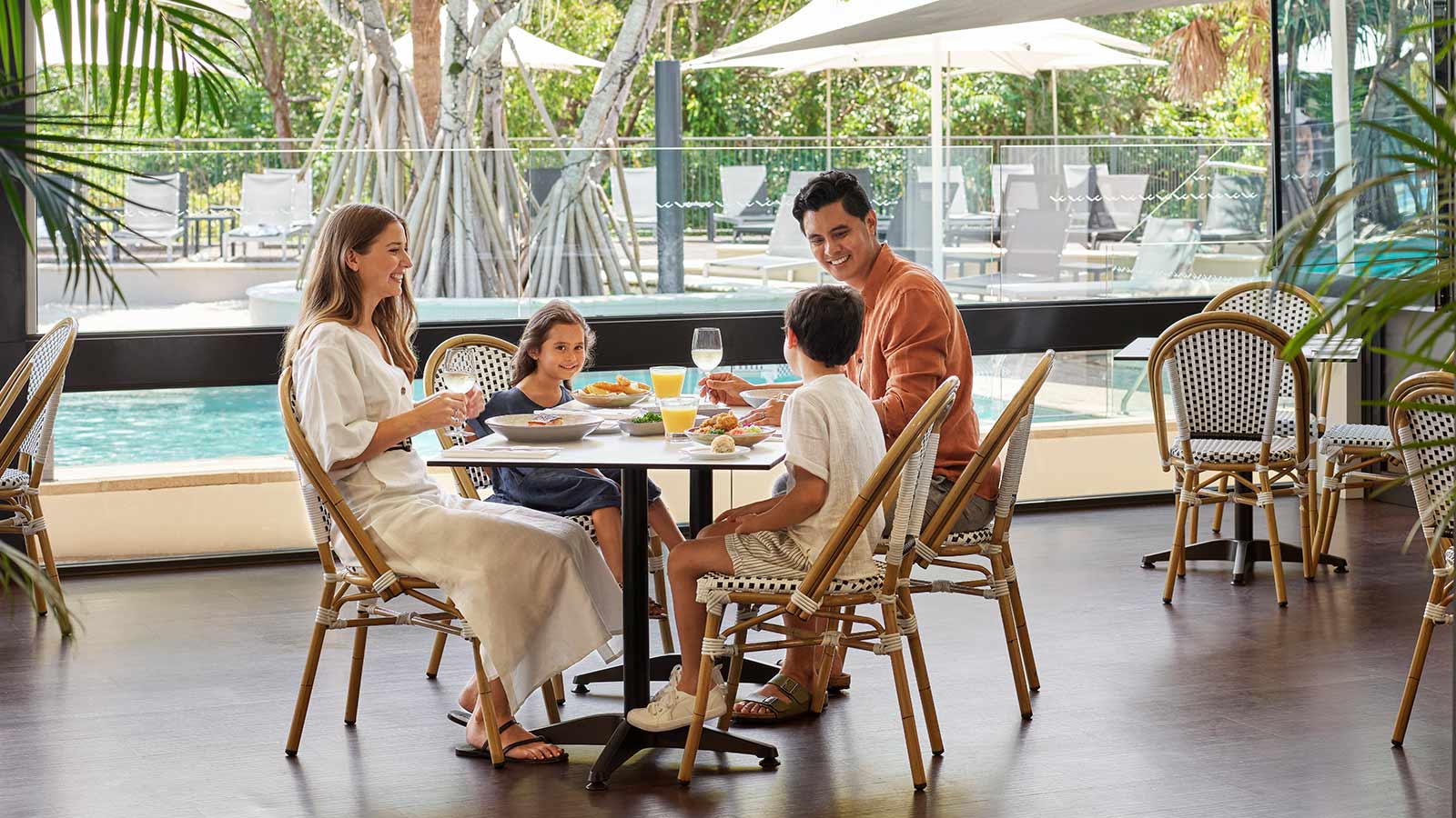 Family dining at RACV's Noosa resort, with views of the pool outside.