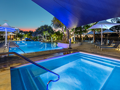 Outdoor pool and spa at sunset at RACV Noosa Resort.