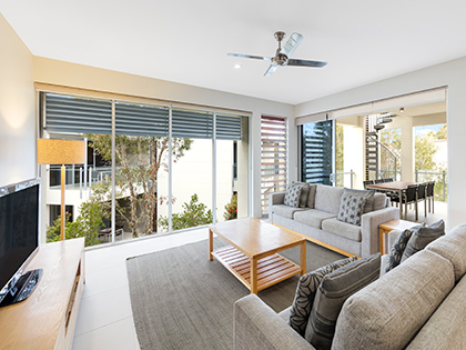 Living area with couches and television in a three bedroom apartment at RACV Noosa Resort.