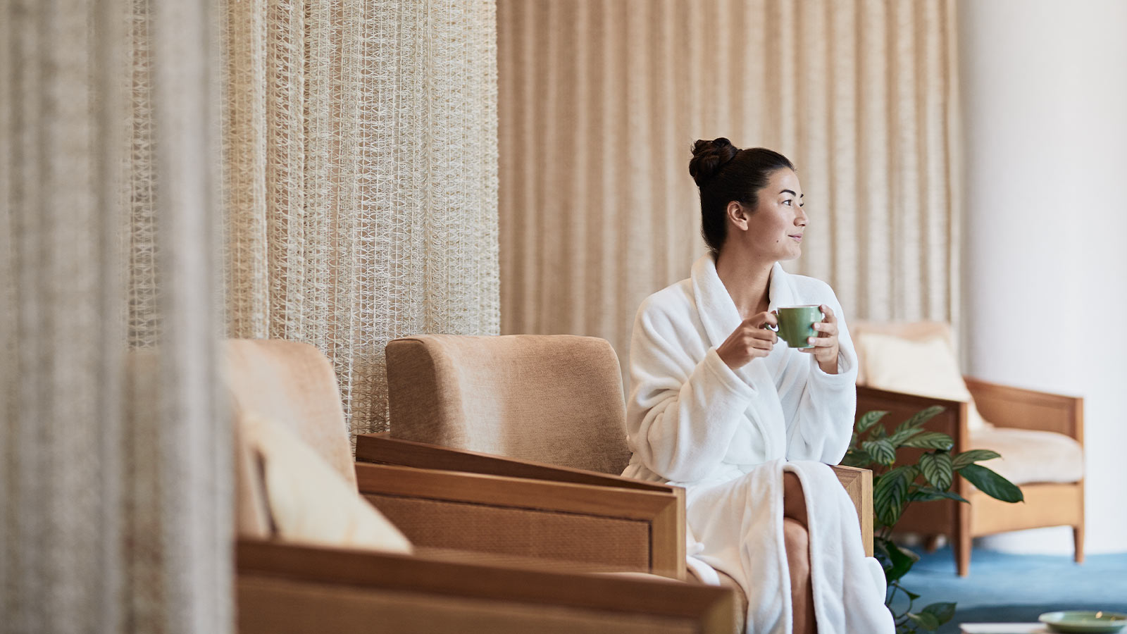 Woman drinking tea in the Healesville one spa relaxation lounge.