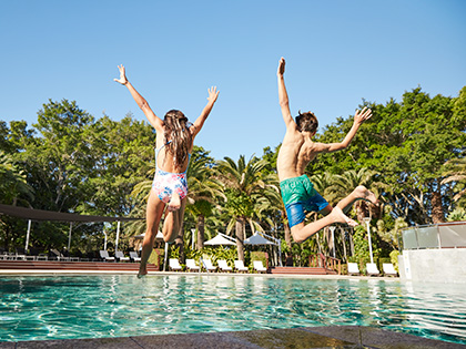 Two children jumping into the RACV Royal Pines outdoor pool.